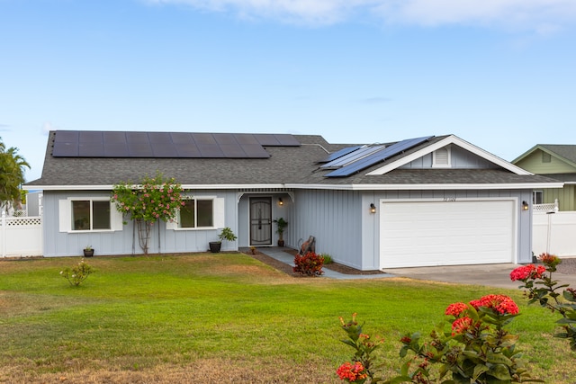 ranch-style home featuring solar panels, a garage, and a front lawn