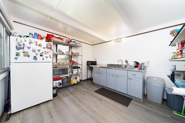 kitchen featuring gray cabinets, white refrigerator, light hardwood / wood-style floors, and sink