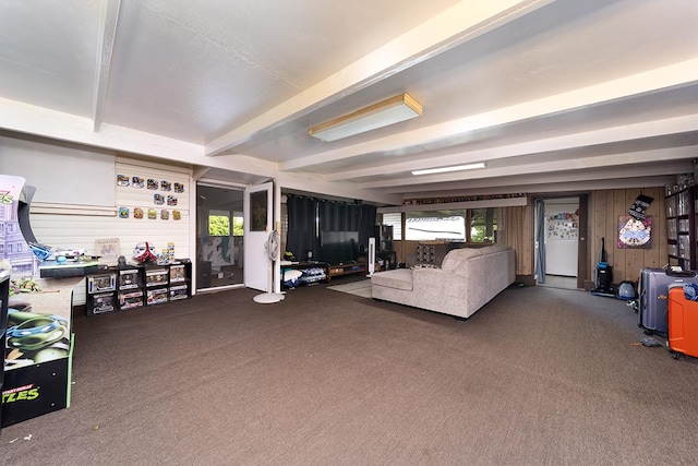 carpeted living room with wood walls and beamed ceiling