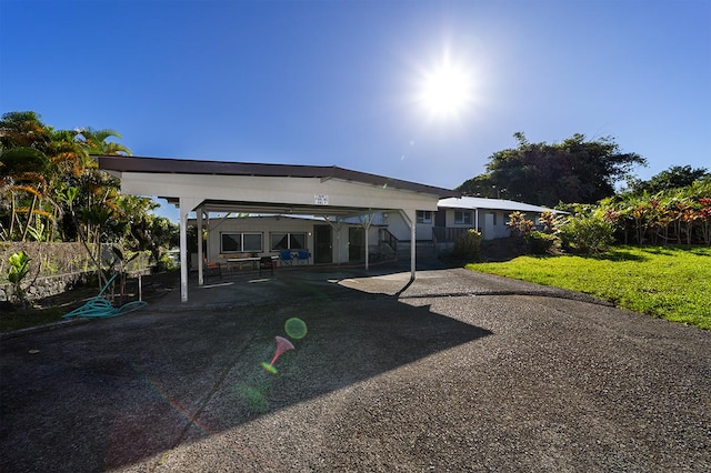 rear view of property featuring a yard and a carport