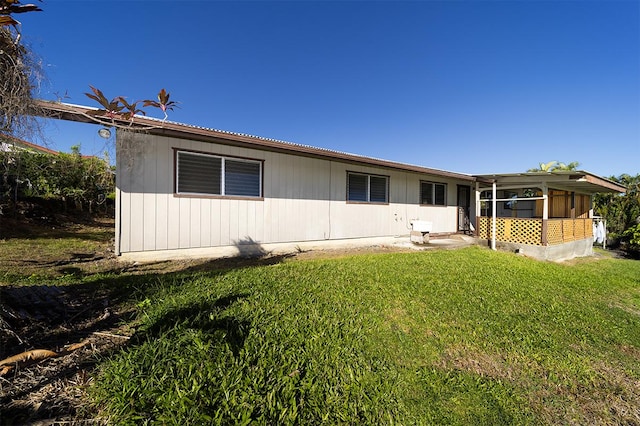 rear view of property with a lawn and a sunroom