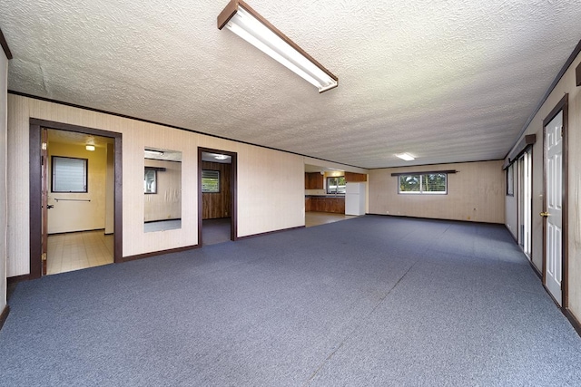 spare room featuring wood walls and a textured ceiling