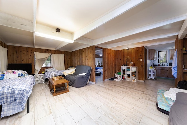 bedroom featuring beam ceiling and wooden walls