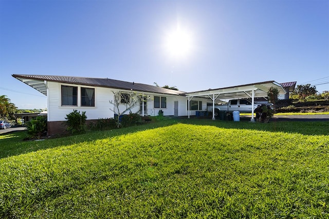 ranch-style home featuring a carport and a front yard