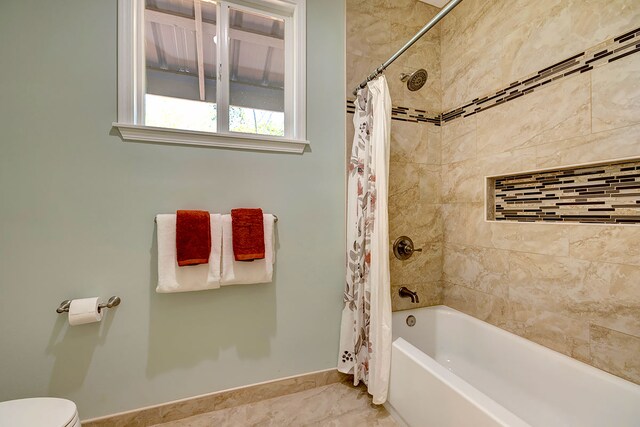 bathroom featuring shower / bath combo, tile patterned floors, and toilet