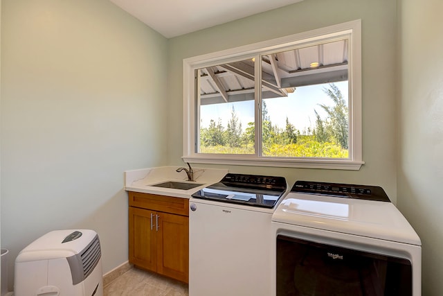 clothes washing area with cabinets, sink, a wealth of natural light, and separate washer and dryer