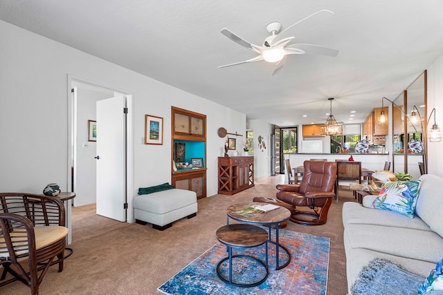 carpeted living room with ceiling fan with notable chandelier