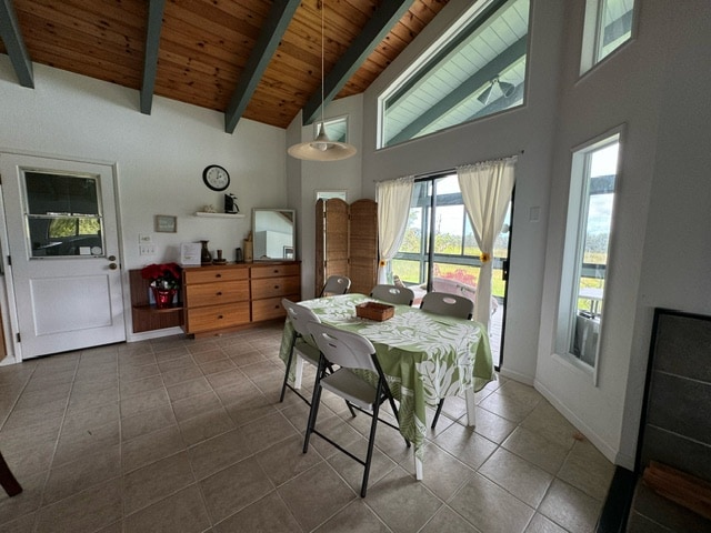 tiled dining room featuring beamed ceiling, high vaulted ceiling, and wooden ceiling