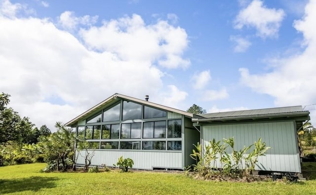 back of house featuring a sunroom and a yard