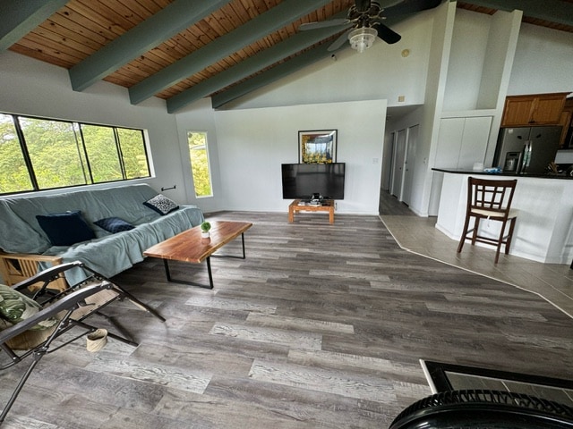 living room featuring beam ceiling, wood ceiling, ceiling fan, wood-type flooring, and high vaulted ceiling