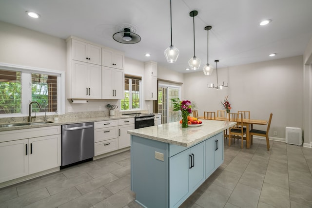 kitchen featuring sink, white cabinetry, appliances with stainless steel finishes, and pendant lighting