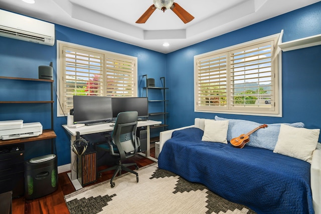 home office featuring ceiling fan, a raised ceiling, wood-type flooring, and a wall mounted air conditioner