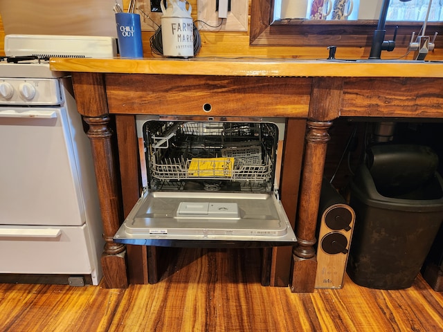 interior details featuring white gas range and hardwood / wood-style flooring