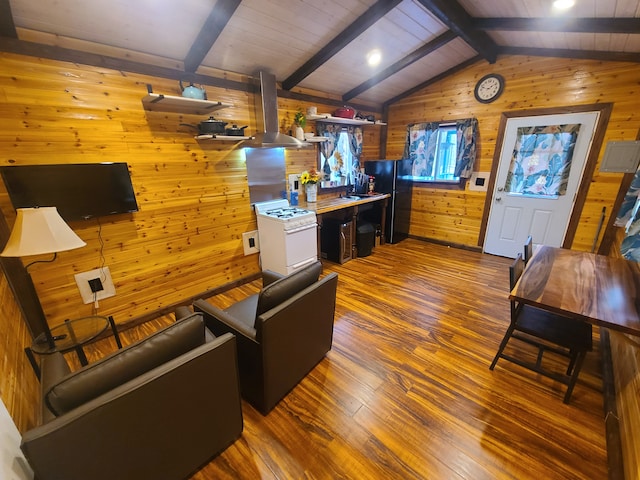 living room with lofted ceiling with beams, hardwood / wood-style flooring, and wooden walls