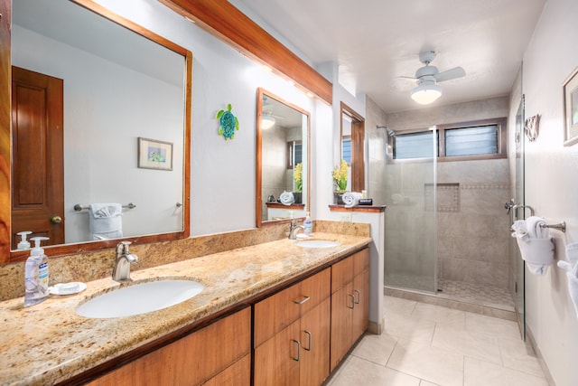 bathroom featuring tile patterned flooring, walk in shower, ceiling fan, and vanity