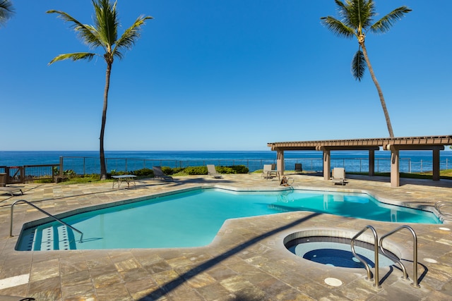 view of swimming pool featuring a water view, a patio, and an in ground hot tub