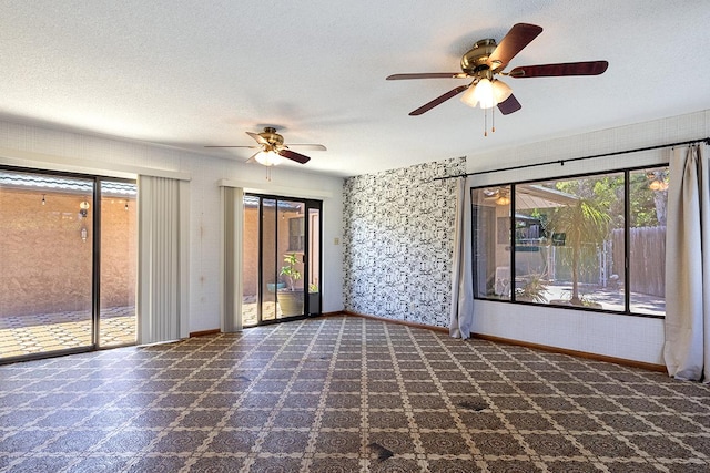 unfurnished room with ceiling fan and a textured ceiling