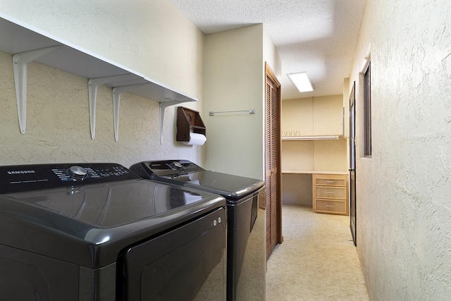 laundry room with light colored carpet, washing machine and dryer, and a textured ceiling