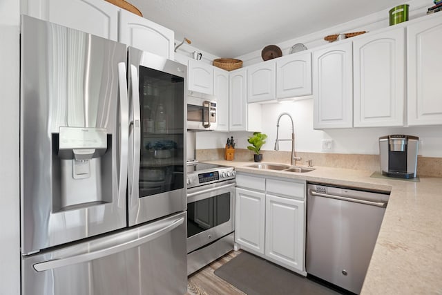 kitchen featuring sink, appliances with stainless steel finishes, white cabinets, a textured ceiling, and dark wood-type flooring