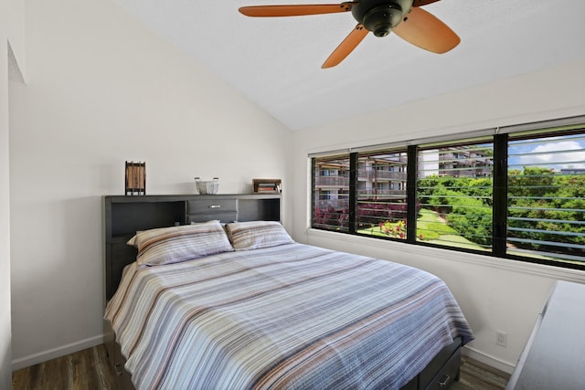 bedroom with ceiling fan, dark hardwood / wood-style flooring, and lofted ceiling