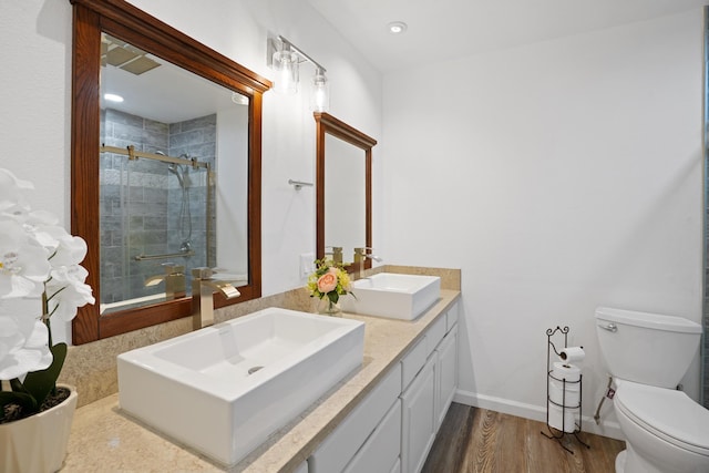 bathroom with toilet, walk in shower, vanity, and hardwood / wood-style flooring