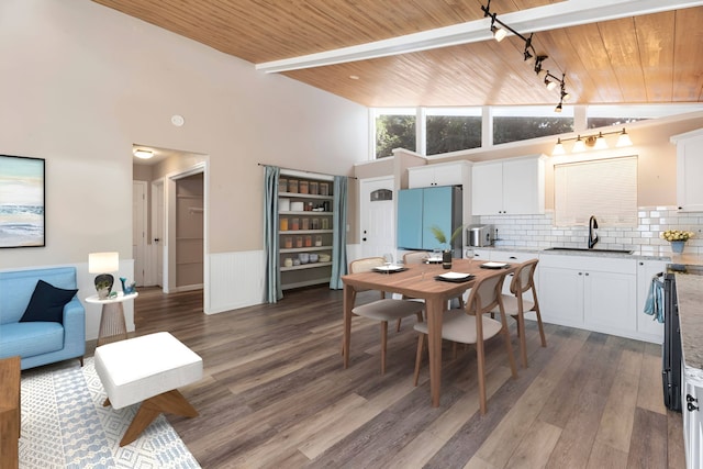 dining space featuring rail lighting, dark hardwood / wood-style flooring, wooden ceiling, and sink