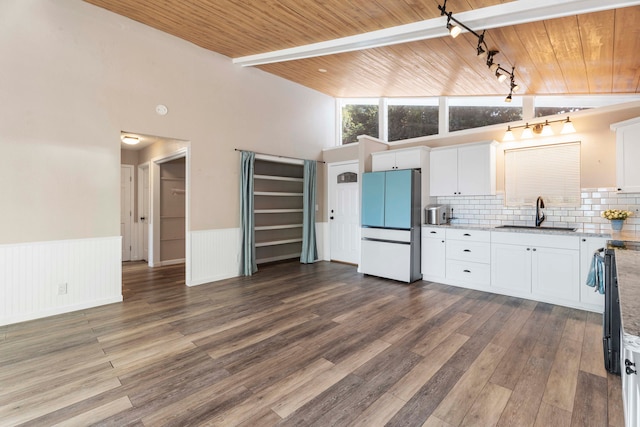 kitchen featuring sink, white cabinets, hardwood / wood-style floors, and fridge