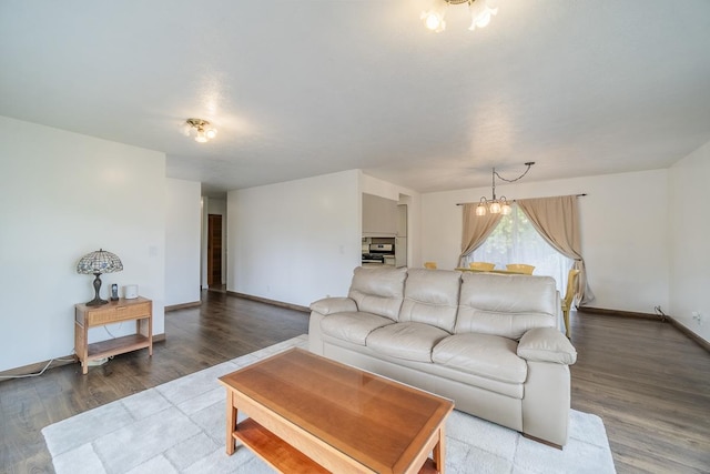 living area featuring baseboards, a chandelier, and wood finished floors