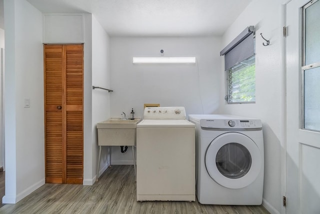 laundry room with light wood-style floors, laundry area, washer and clothes dryer, and baseboards