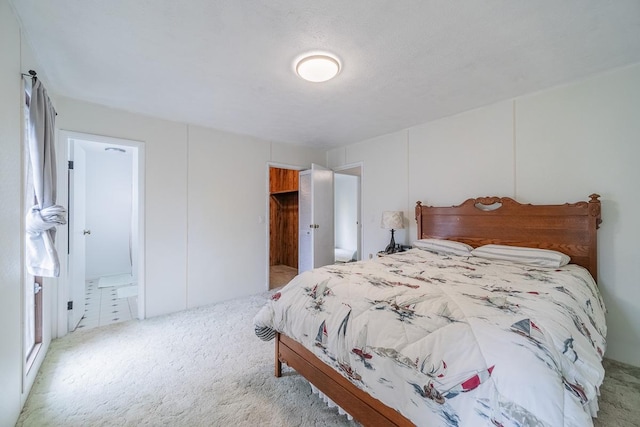 bedroom with light carpet and ensuite bathroom