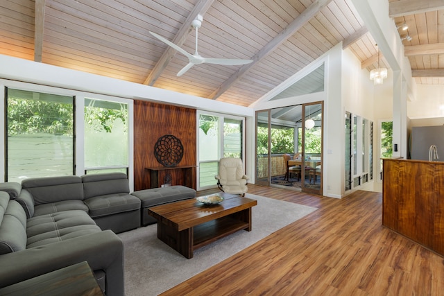 living room featuring wood ceiling, ceiling fan, beamed ceiling, and a healthy amount of sunlight