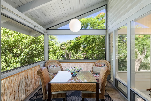 sunroom featuring plenty of natural light and lofted ceiling with beams