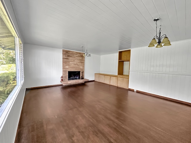 unfurnished living room featuring a fireplace, dark wood-type flooring, and brick wall