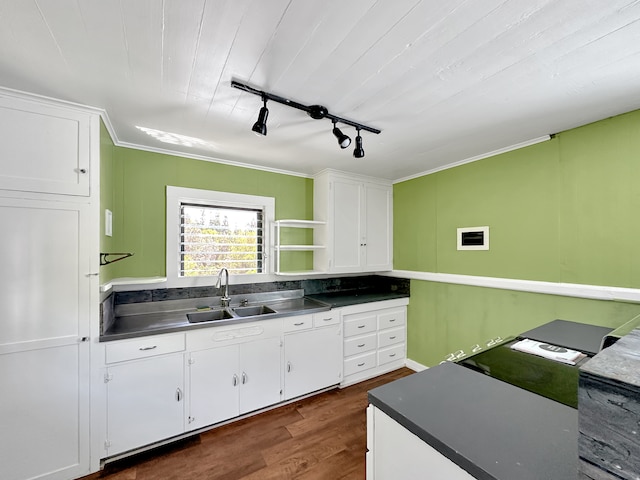 kitchen featuring white cabinetry, crown molding, dark wood-type flooring, track lighting, and sink