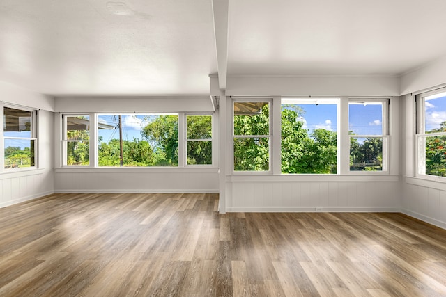 unfurnished sunroom featuring beam ceiling