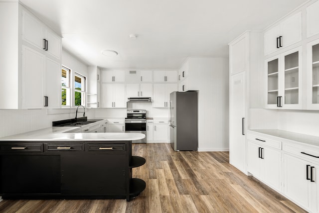 kitchen featuring sink, appliances with stainless steel finishes, wood-type flooring, and white cabinetry