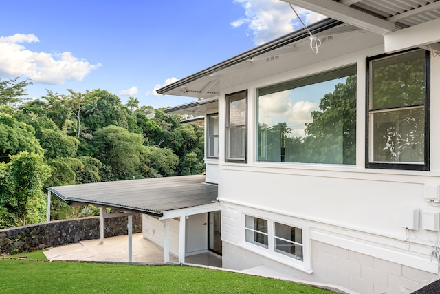 view of home's exterior with a patio area and a lawn