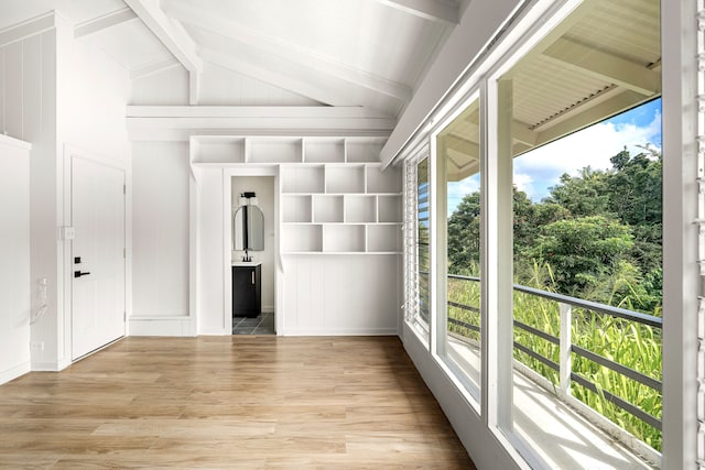 unfurnished sunroom featuring a wealth of natural light and lofted ceiling with beams