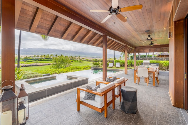 view of patio / terrace featuring a mountain view, a pool with hot tub, and ceiling fan