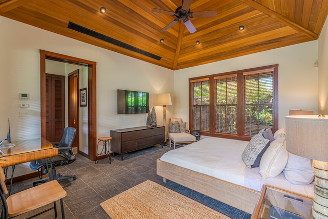 bedroom with ceiling fan, dark tile patterned flooring, and wooden ceiling