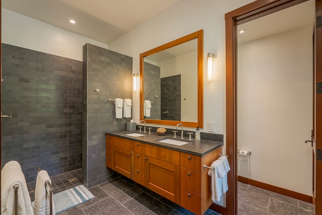 bathroom featuring tile patterned floors, dual bowl vanity, and a tile shower