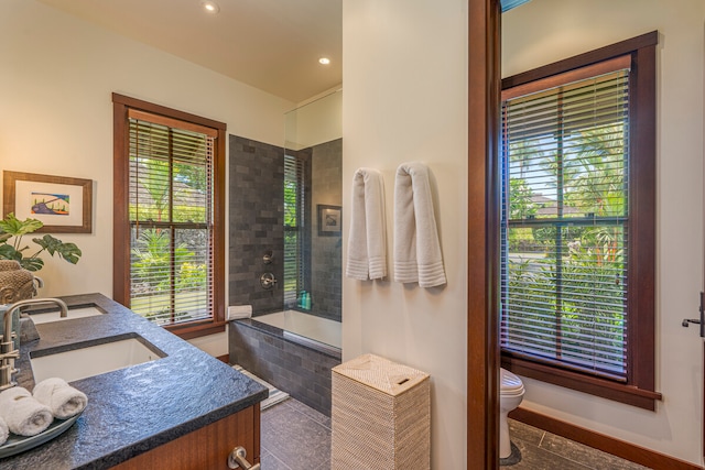 full bathroom featuring toilet, tile patterned floors, and a healthy amount of sunlight