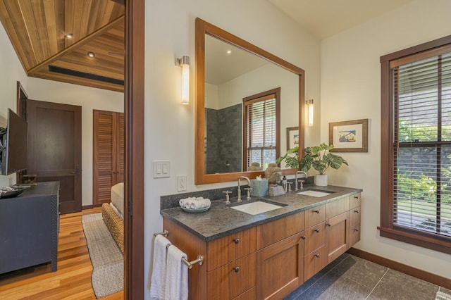 bathroom with double vanity, a sink, and baseboards