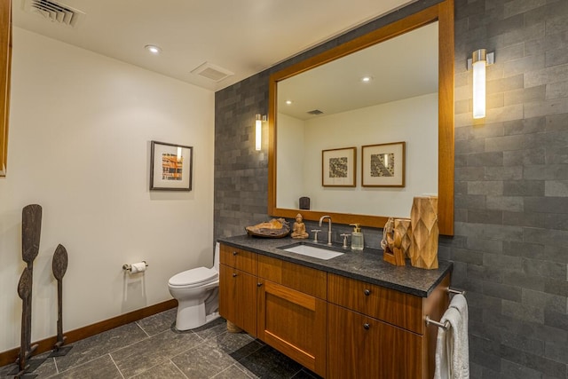 bathroom with toilet, baseboards, visible vents, and vanity