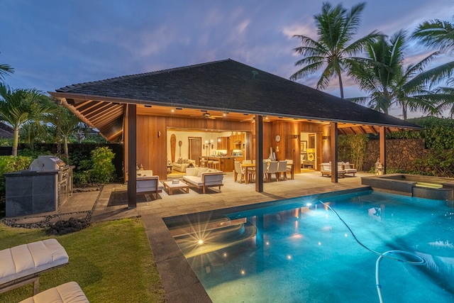 pool at dusk featuring a patio and an outdoor hangout area