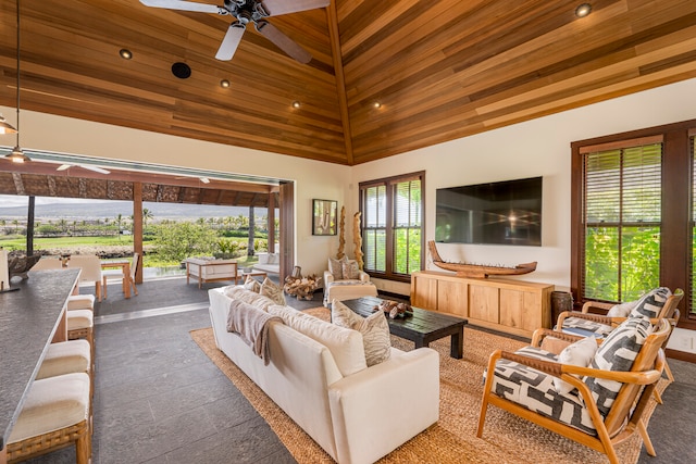 living room with ceiling fan, a healthy amount of sunlight, wooden ceiling, and a high ceiling