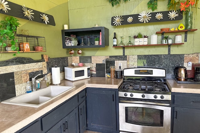 kitchen featuring stainless steel gas stove, backsplash, and sink