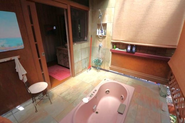 bathroom with tiled tub and tile patterned flooring