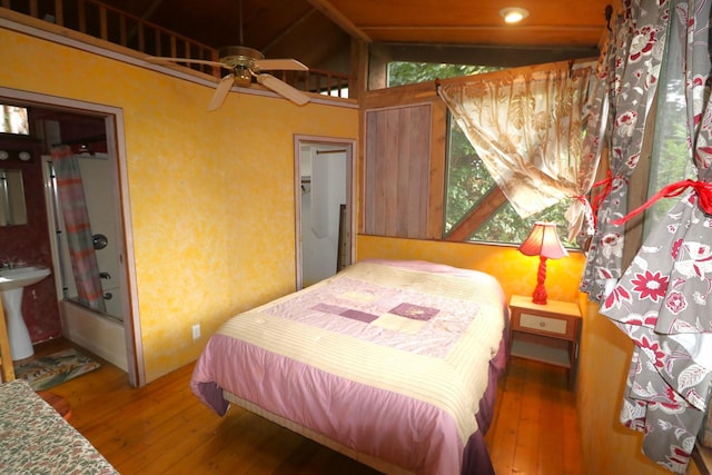 bedroom with hardwood / wood-style flooring, lofted ceiling, and sink