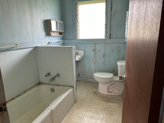 bathroom with wood walls, tile patterned flooring, and toilet